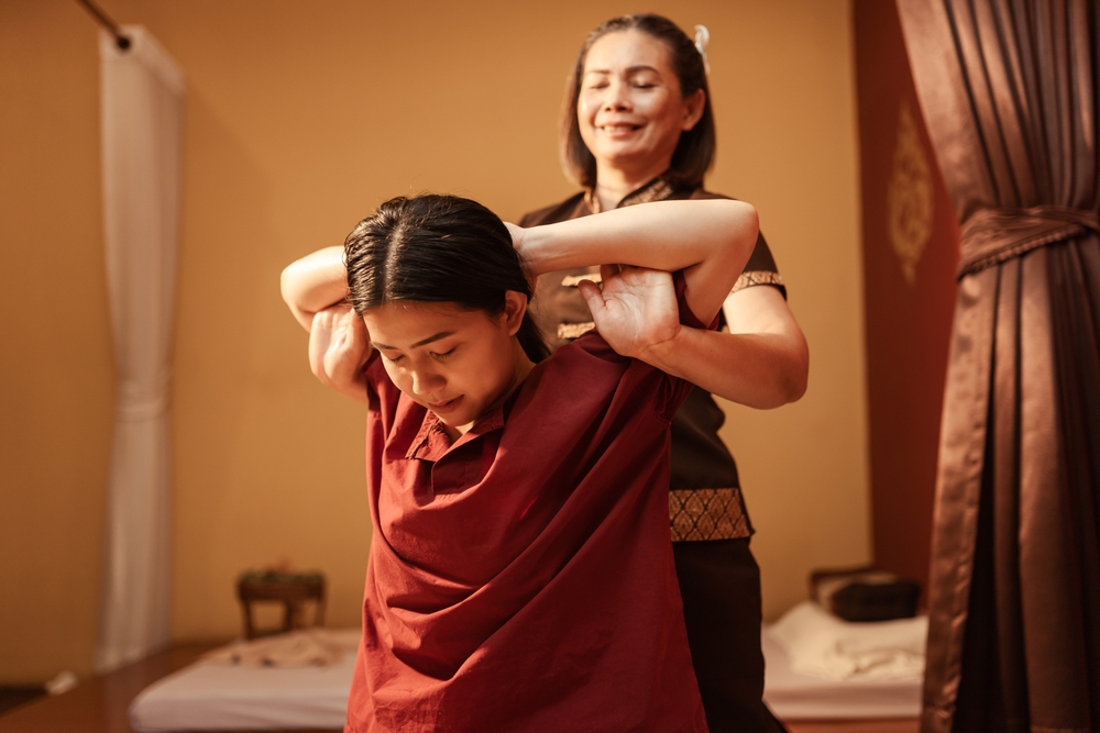 Massage therapist doing thai massage stretch for arms on customer - Pan Thai Massage - Sugar Land, TX